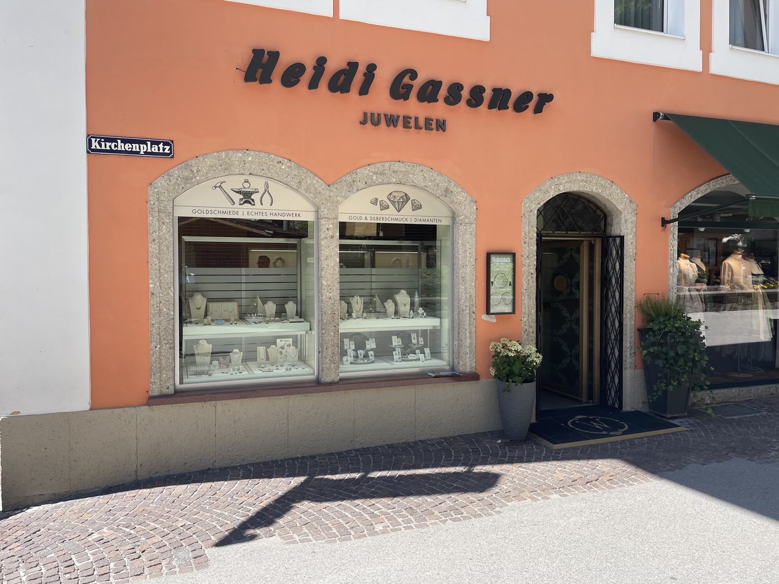 Ladenfront von Heidi Gassner Juwelen am Kirchenplatz in Bad Hofgastein, daneben das Strassenschild Kirchenplatz